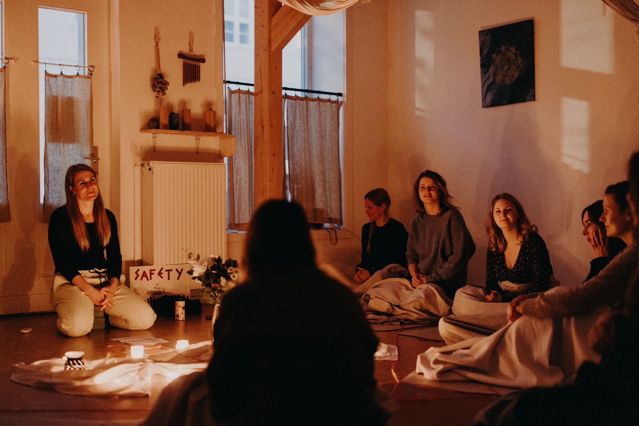 Circle of Care mit Doula Nadine Birner in Neustrelitz: Schwangere und vertraute Menschen sitzen bei Kerzenlicht im Kreis und zelebrieren Gemeinschaft und Fürsorge rund um Schwangerschaft, Geburt und Mutterwerden.